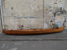 A marine ply Canadian canoe with paddles named 
