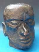 A cast iron sculpture of a male head