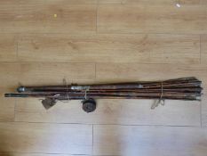 A collection of fishing rods and wooden reels together with a a Bowness & Bowness example