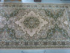A large green and yellow on a beige ground rug (503xm x 274cm)