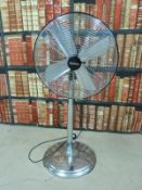 A chrome adjustable floor fan