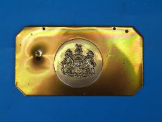 A Rhodesian brass headman's badge with bullet mark