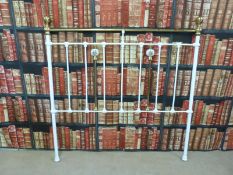 A brass bedhead with decorative ceramic adornments