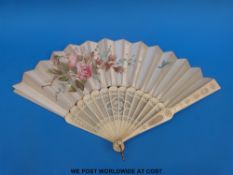 A 19thC hand decorated bone folding fan with carved and pierced guard sticks.