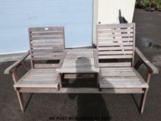 A teak garden seat or companion bench with cushions