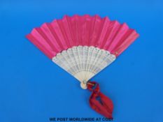 A 19thC bone folding hand fan with uniform pierced guard stick,