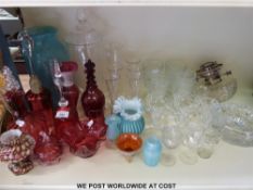 A large selection of glassware to include an engraved red decanter with ringed neck and stopper,