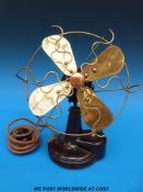 A vintage EMI brass and bakelite desk fan with attachment to run from a light bulb socket