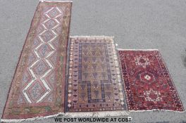 Three wool rugs each with pink hue on geometric design,