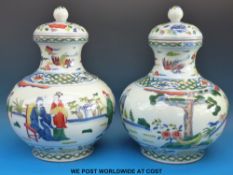 A pair of Chinese vases and covers in the Wucai style with character marks to base (33cm tall)