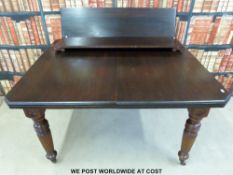 A mahogany extending dining table with two additional leaves and a winder,