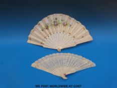 A 19thC bone fan with pierced sticks and decoration of flowers to the leaves (25cm),