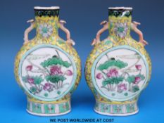 A pair of 19thC Chinese famille jaune moon flasks/ vases with bird and floral decoration on a