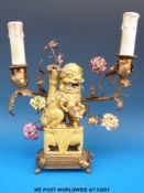 An early electric twin-branched candelabra table lamp in the form of a Fu Dog with metal label to