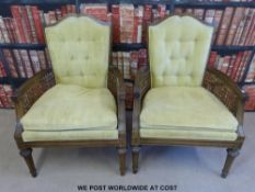A pair of upholstered armchairs with wicker sides,