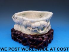 A Chinese greenish white jadeite brush washer carved in relief with prunus blossom,