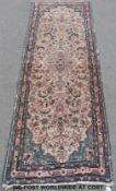 A pink ground runner with blue border and stylised floral motifs (244cm x 85cm)
