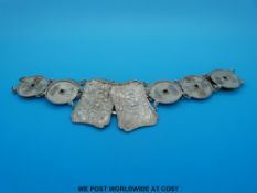 A Chinese white metal belt in the form of 12 coins decorated with symbols,