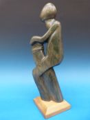 An African or Intuit stone carving on a wooden base