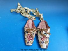 A pair of Chinese silk slippers with embroidered floral decoration,