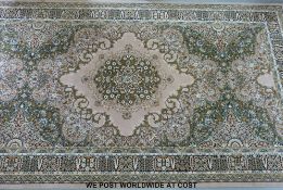 A large wool rug on beige and green ground in floral and foliate design (4.5 metres x 2.
