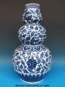 A 19thC Chinese triple gourd vase with all over decoration of flowers and foliage (39.