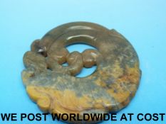 A Chinese green jade pendant in the form of an archaistic dragon (6.