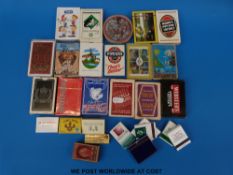 A collection of playing cards including advertising and a collection of match boxes and match books