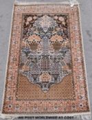 A silk rug decorated with a floral and foliate design, urns of flowers with birds etc.