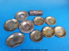 Nine Japanese pewter and gilt metal trays all with embossed decoration of figures,