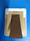 A ceramic photograph frame decorated with flowers