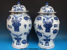 A pair of large Chinese blue and white jars decorated in the 100 Antiques pattern (47cm tall)