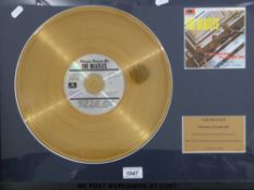 A framed (18” x 23”) “Gold” disc of The Beatles “Please Please Me” LP.