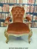 A 19thC carved walnut upholstered armchair raised on ceramic castors