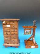 A miniature chest of 14 drawers all with ring handles together with an oak musical lamp with