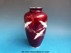 A Japanese Meiji period silver wire knot and and cloisonné vase decorated with cranes on a red