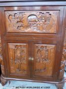 A Chinese highly carved dark elm drinks cabinet and bar.