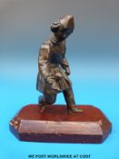 A bronze figure of a street entertainer with a spinning top in the palm of his hand,