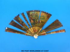 A 19thC cased painted bone brisé folding fan with hand decorated village gathering and village