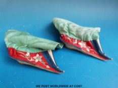 A pair of Chinese silk lotus shoes with embroidered decoration.