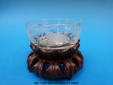 An 18thC engraved glass teabowl on hardwood stand