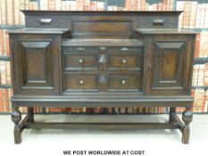 An oak 20thC sideboard with two drawers flanked by cupboards (w154 x d52 x h114cm)