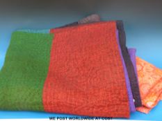 A large woollen quilted bedspread and some bolts of retro fabric