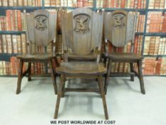 A set of four oak solid seat chairs with armorial lion to backs