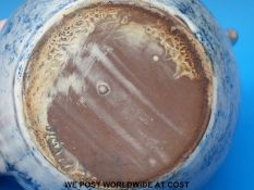 An earthenware teapot, cream slip with cobalt blue brushwork and incised signature,