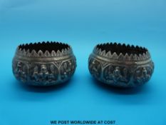 A pair of Indian white metal bowls with embossed decoration of goddesses (8cm diameter)