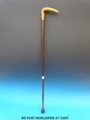A horn handled late 19thC/early 20thC walking stick with wrythen carved and bent handle and gilt