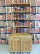 A pine bookcase together with a pine cupboard or TV stand