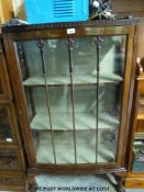 An early 20thC glazed display cabinet raised on cabriole legs with ball and claw feet (w72 x d32 x