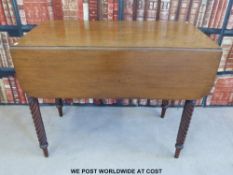 A mahogany drop leaf table raised on spiraling turned legs (l90cm x h73cm)